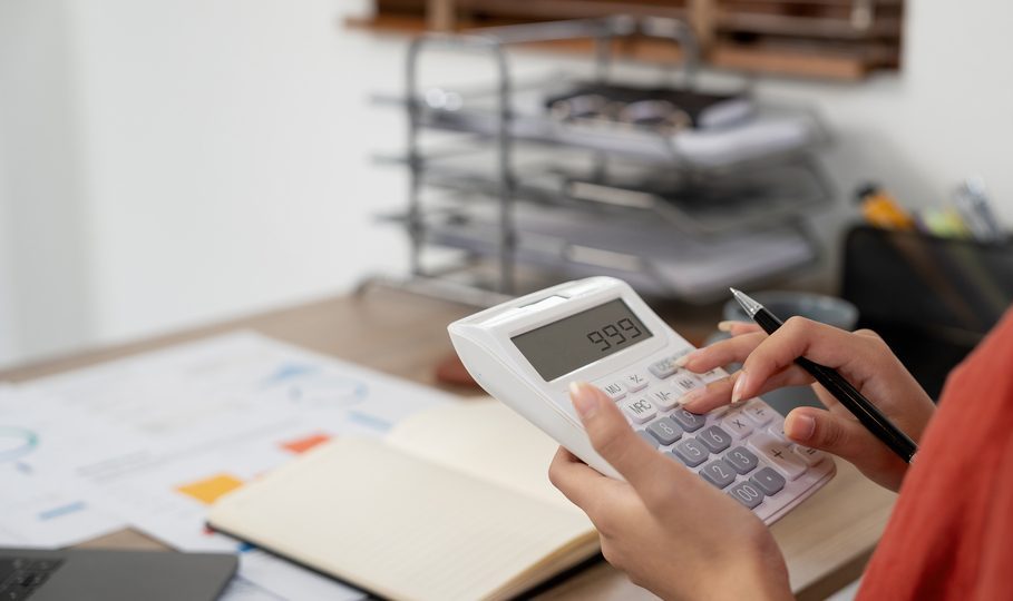 Close up hands businessman doing finances with using calculator for debt or tax